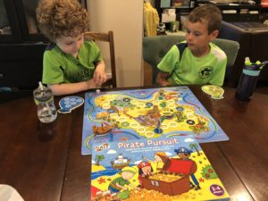 Two young boys play a board game. 